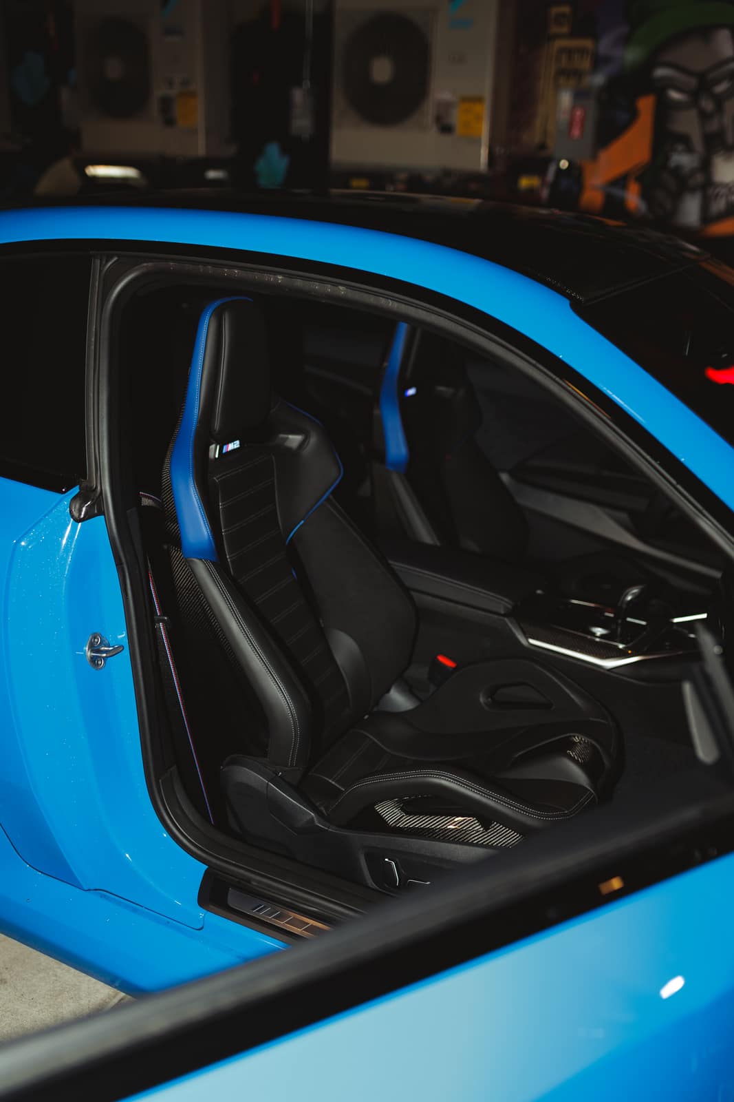 Interior through the open door: M carbon seats with blue stitching