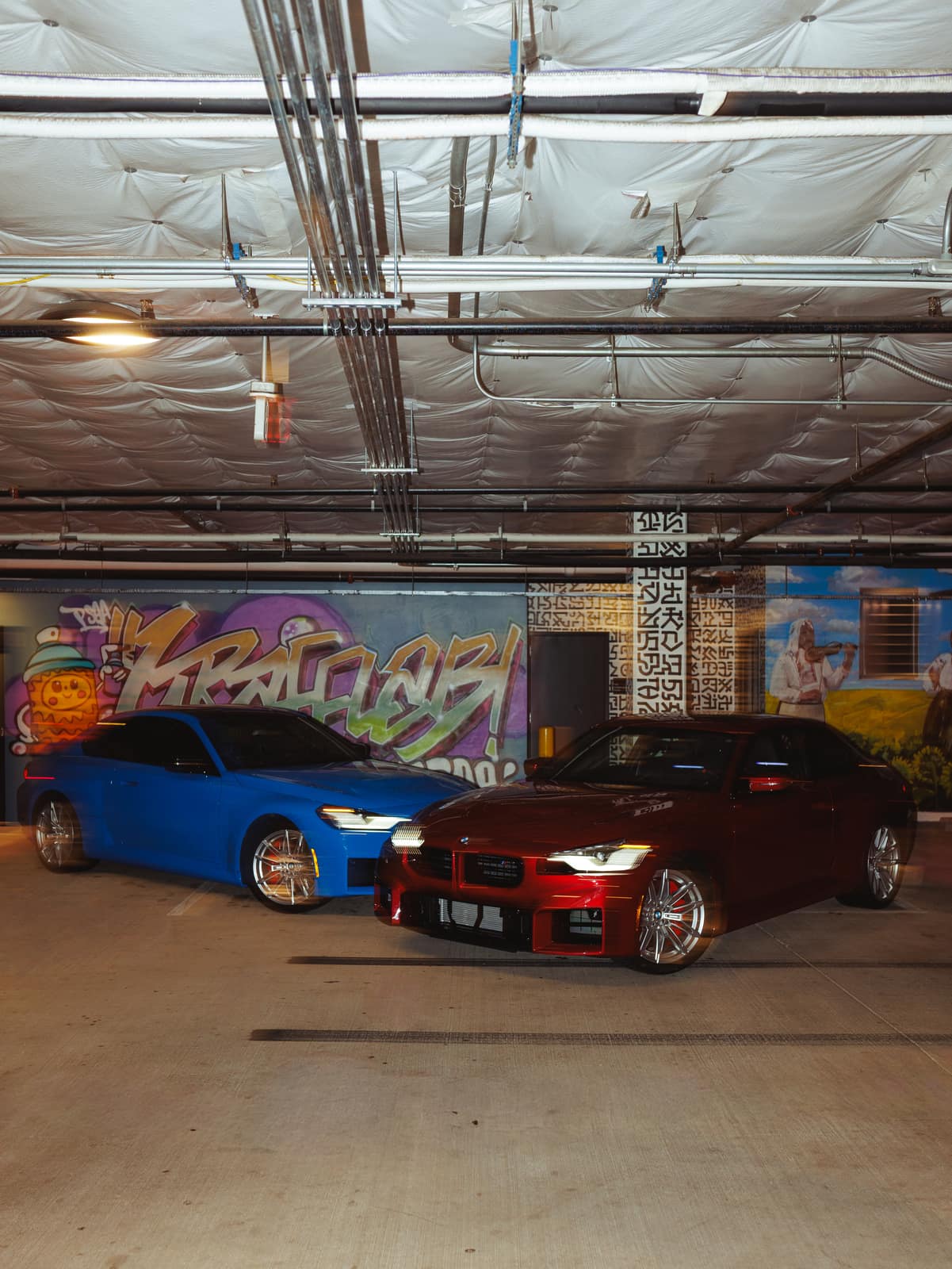 Both cars nose-out in the painted underground garage