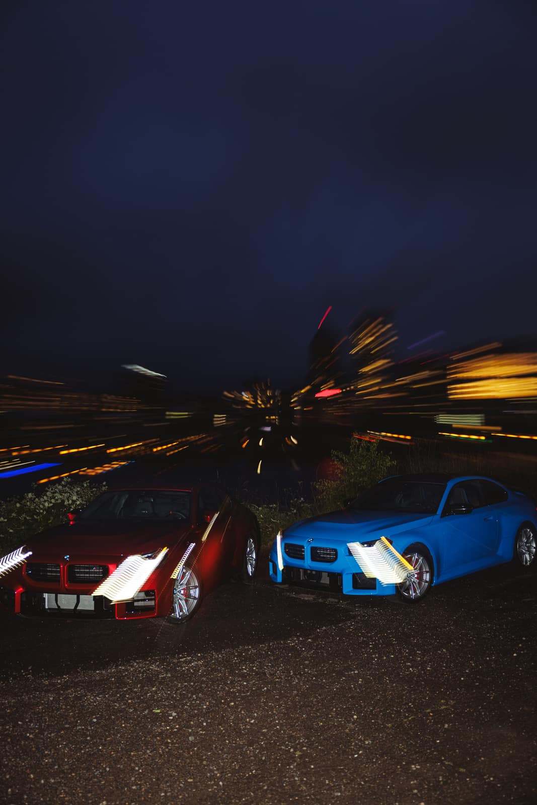 City lights streaking behind the two cars in a long exposure
