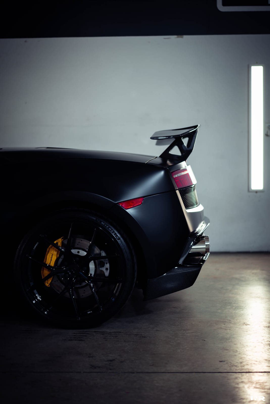 Rear quarter detail: wing upright, fender, and wheel