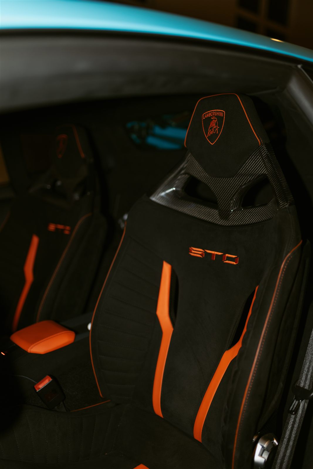 Carbon-backed STO racing seat in black alcantara with orange stitching