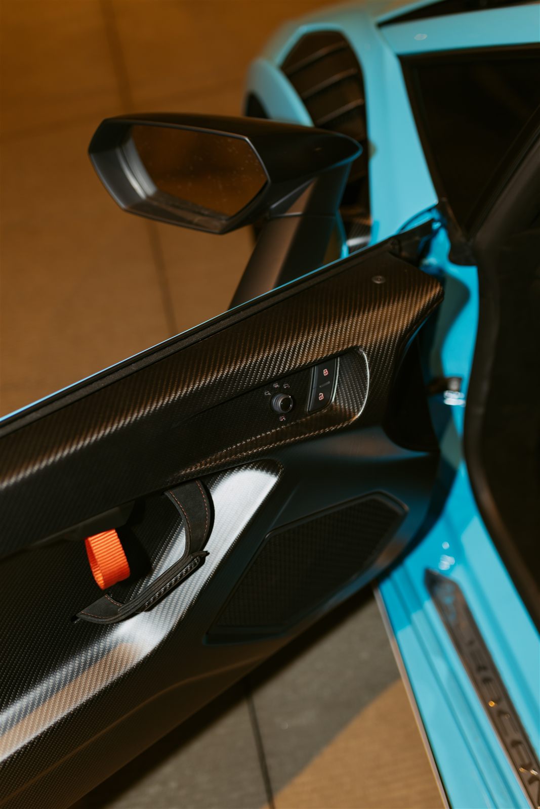 Carbon door panel with the orange pull strap