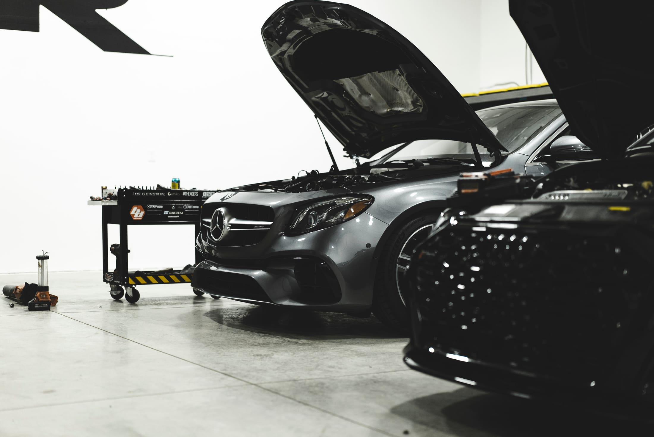 Mercedes-AMG E63 with the hood up in the INR service bay